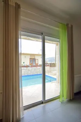 a room with a sliding glass door with a view of a swimming pool at Villa Nopigia Mare in Kissamos