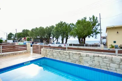a swimming pool with a retaining wall and a stone wall at Villa Nopigia Mare in Kissamos