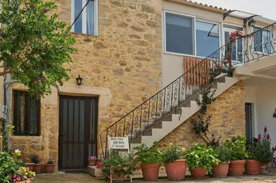a stone building with a staircase and potted plants at Batilas Garden House in Kissamos