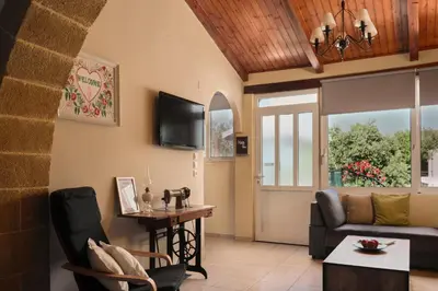 a living room with a couch and a tv at Batilas Garden House in Kissamos