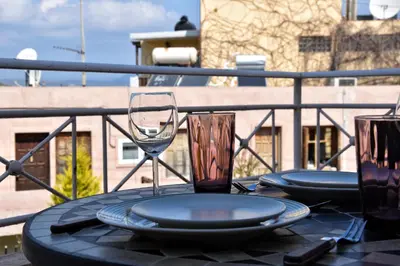 a table with plates and a wine glass on a balcony at Casa de Campo 1 in Almirida