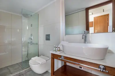 a bathroom with a sink and a toilet and a shower at Vener Luxury Suites in Chania Town