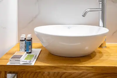a white bowl sink on a wooden counter in a bathroom at Vener Luxury Suites in Chania Town