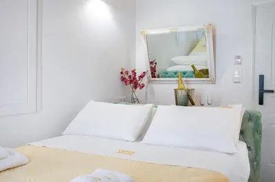 a white room with a bed with a mirror at Vener Luxury Suites in Chania Town