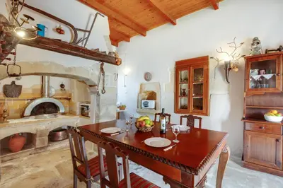 a kitchen with a wooden table and a fireplace at Traditional Home Vereniki With Heated Pool - BY APOKORONAS VILLAS in Gavalochori