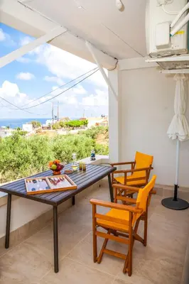 a dining room with a table and chairs and the ocean at Tranquility House in Livadia