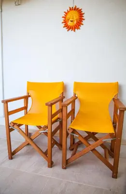 two yellow chairs sitting next to a wall at Tranquility House in Livadia