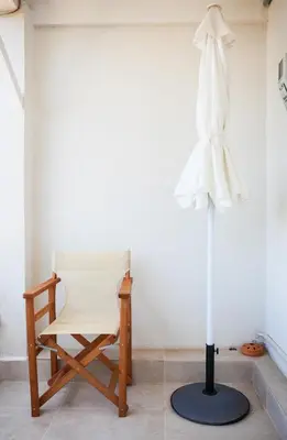 a white chair and a dress hanging on a wall at Tranquility House in Livadia