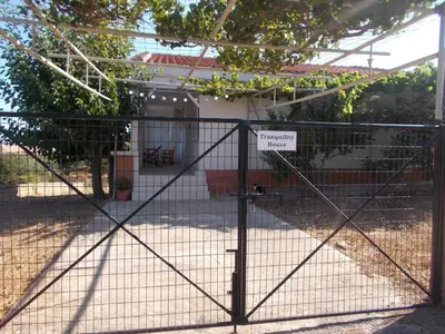 a gate with a sign on it in front of a house at Tranquility House in Livadia