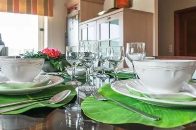 a table with plates and wine glasses on it at Orange Tree Garden vacation home in Ayiá