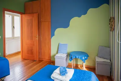 a bedroom with a blue and green wall at Orange Tree Garden vacation home in Ayiá