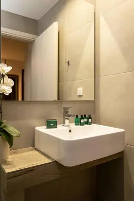 a bathroom with a white sink and a mirror at NV One in Chania Town