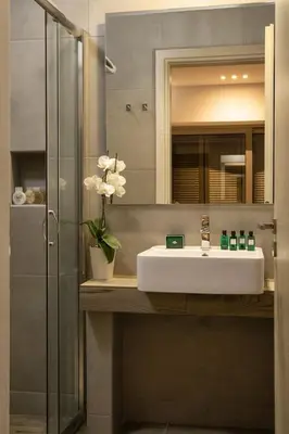 a bathroom with a sink and a glass shower at NV One in Chania Town