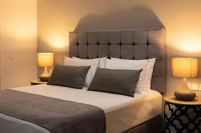a bedroom with a large bed with two lamps at NV One in Chania Town