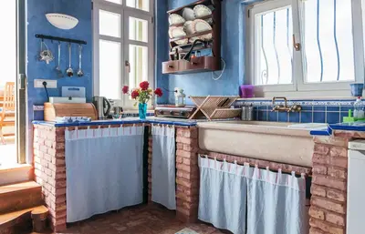 a kitchen with blue walls and a sink and a counter at MaGea-Thalassa,Top floor Cretan studio with views in Tavronitis