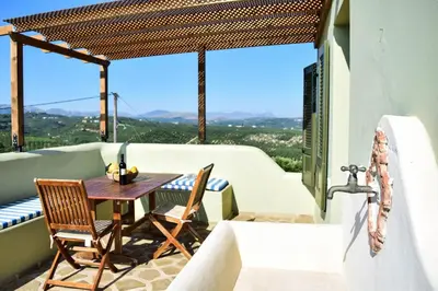 a patio with a table and chairs on a balcony at MaGea-Thalassa,Top floor Cretan studio with views in Tavronitis