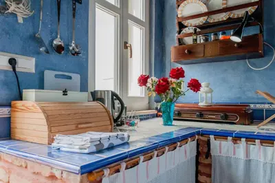 a kitchen with a counter with red flowers in a vase at MaGea-Thalassa,Top floor Cretan studio with views in Tavronitis