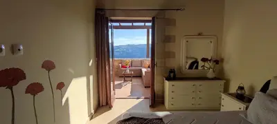 a bedroom with a door open to a room with a mirror at Vasiliki's Residence - Breathtaking View in Kissamos