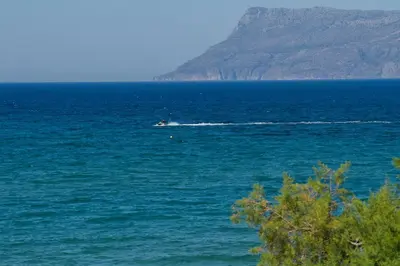 a boat in the middle of a large body of water at Mavros Molos Seaside Apartment in Kissamos