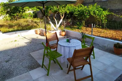 a table and chairs under an umbrella on a patio at Sunday Apartment Chania 2A in Chania Town