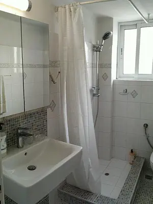 a white bathroom with a sink and a shower at Sunday Apartment Chania 2A in Chania Town