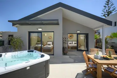 a house with a hot tub in the yard at Sun Ray Beach Life Villa in Agia Marina Nea Kydonias