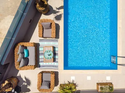 an overhead view of a swimming pool with chairs and a clock at Sun Ray Beach Life Villa in Agia Marina Nea Kydonias