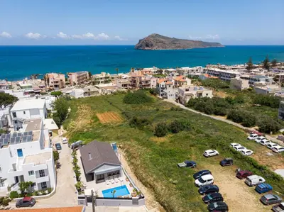 an aerial view of a town with a parking lot and the ocean at Sun Ray Beach Life Villa in Agia Marina Nea Kydonias