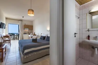a bedroom with a bed and a bathroom at Kanso Rooms in Galatás