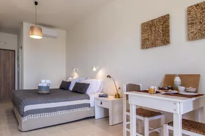 a bedroom with a bed and a desk with a desk at Kanso Rooms in Galatás