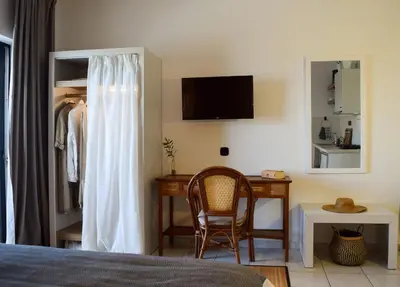 a bedroom with a desk and a bed and a chair at Kanso Rooms in Galatás
