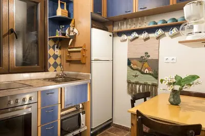 a small kitchen with a table and a refrigerator at House Erofili in Chania Town
