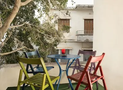 four chairs and a table with a red candle on it at House Erofili in Chania Town