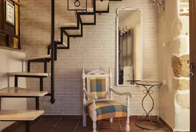 a room with a chair and a brick wall at House Erofili in Chania Town