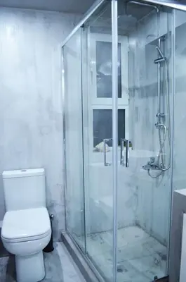 a bathroom with a glass shower and a toilet at MV House Agia Marina in Agia Marina Nea Kydonias