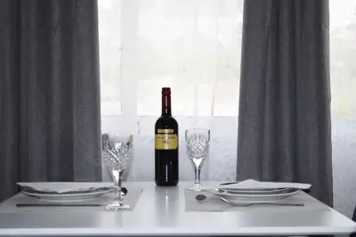a bottle of wine sitting on a table with glasses at MV House Agia Marina in Agia Marina Nea Kydonias