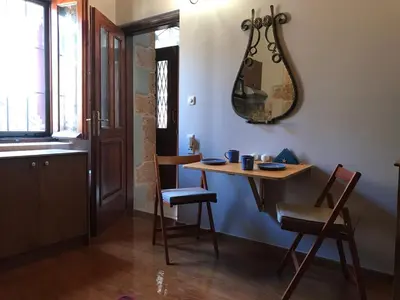 a dining room with a table and chairs and a mirror at Microcosmos Halepas in Chania Town