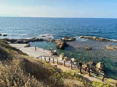 a group of people in the water at a beach at Microcosmos Halepas in Chania Town