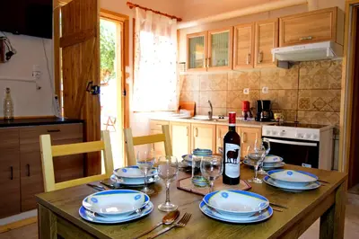 a wooden table with a bottle of wine and glasses at Sea Lake Holiday House in Elafonisi