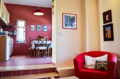 a living room with a red chair and a table at MaGea- Asterias Ground floor peaceful apartment in Tavronitis