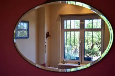 a mirror reflecting a room with a window at MaGea- Asterias Ground floor peaceful apartment in Tavronitis
