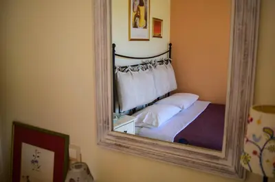 a mirror on a wall with a bed in a room at MaGea- Asterias Ground floor peaceful apartment in Tavronitis