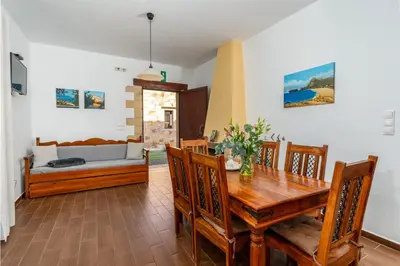 a dining room with a wooden table and chairs at Stay in Falassarna Villas in Falasarna