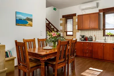 a kitchen with a wooden dining room table and chairs at Stay in Falassarna Villas in Falasarna