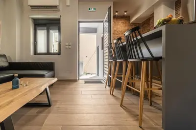 a living room with a wooden table and chairs at MOS Luxury City Suites - The R suite in Chania Town