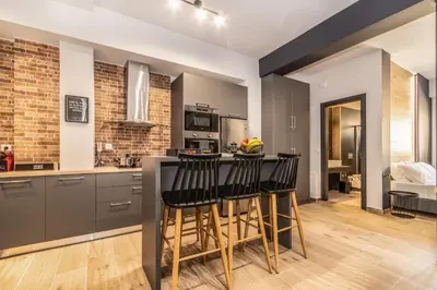 a kitchen with a bar with black counter stools at MOS Luxury City Suites - The R suite in Chania Town