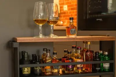 a shelf with two glasses and bottles of alcohol at MOS Luxury City Suites - The R suite in Chania Town