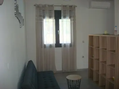 a living room with a couch and a window at Chania Olive Home in Kato Daratso