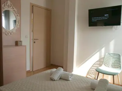 a bedroom with a bed and a chair and a television at Chania Olive Home in Kato Daratso