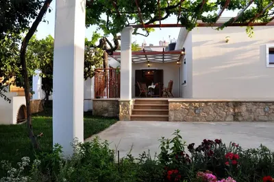 a white house with a patio and a table at Anna 's House - Garden Cottage in Kissamos in Kissamos